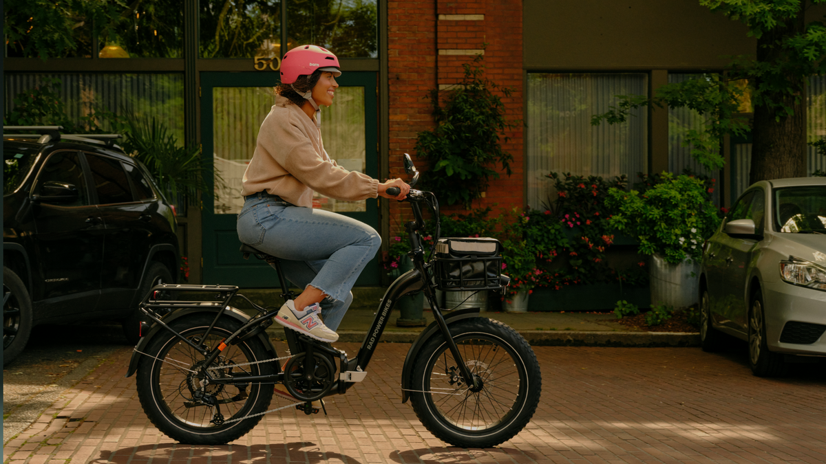 Woman wearing a pink helmet riding an electric bike