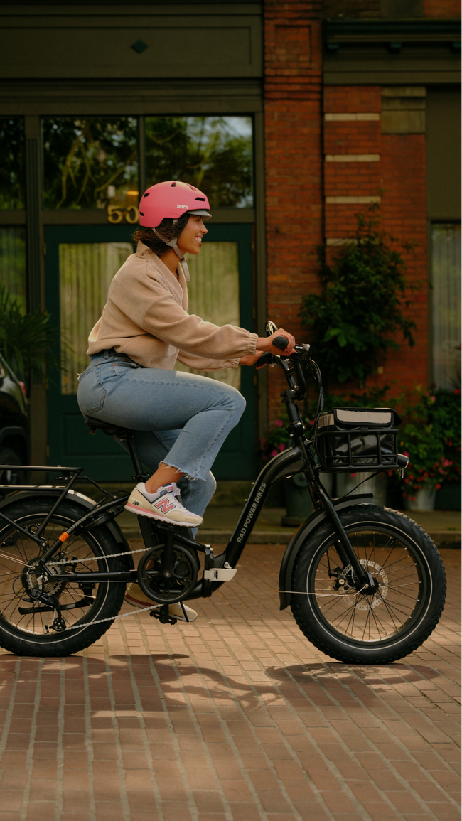 Woman wearing a pink helmet riding an electric bike